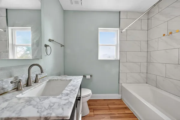 a bathroom with a sink and mirror with bathtub