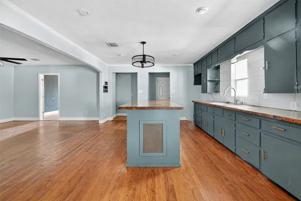 a kitchen with stainless steel appliances granite countertop a sink stove and wooden floor