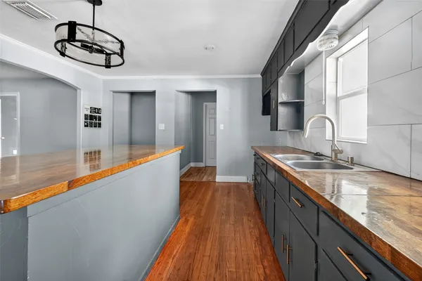 a view of a kitchen with a sink and wooden floor