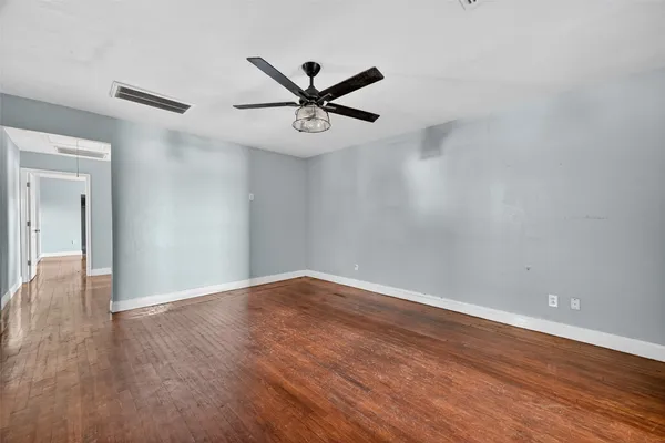 a view of an empty room with wooden floor