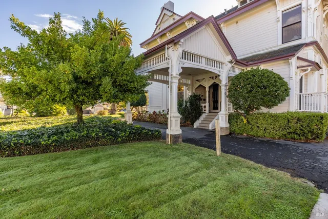 a view of a house with a small yard and potted plants