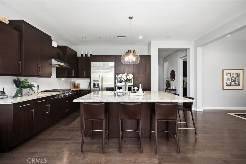 3 Planeo Rancho Mission Viejo, CA 92694 - Photo 9 of 37 a kitchen with stainless steel appliances kitchen island granite countertop a table chairs sink and cabinets