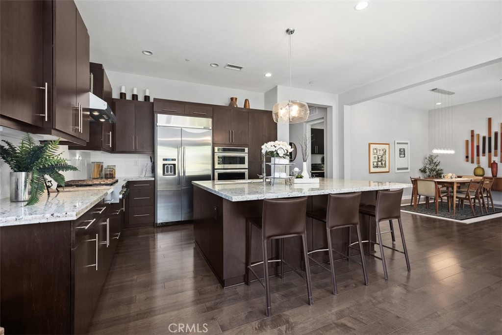 3 Planeo Rancho Mission Viejo, CA 92694 - Photo 10 of 37 a kitchen with stainless steel appliances kitchen island granite countertop a table chairs sink and cabinets