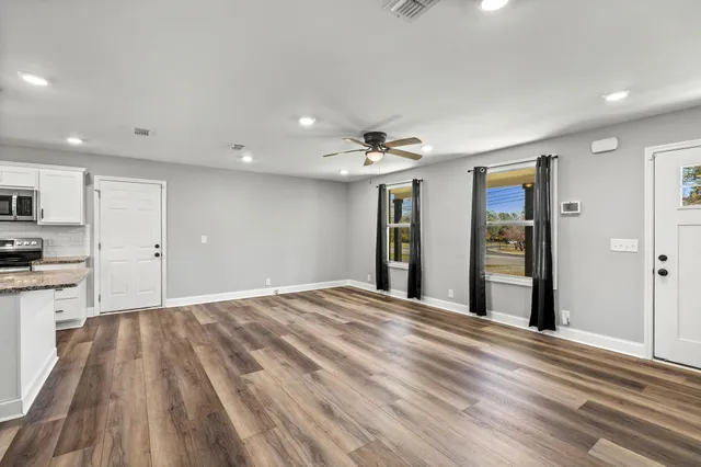 a view of a kitchen with wooden floor and a refrigerator