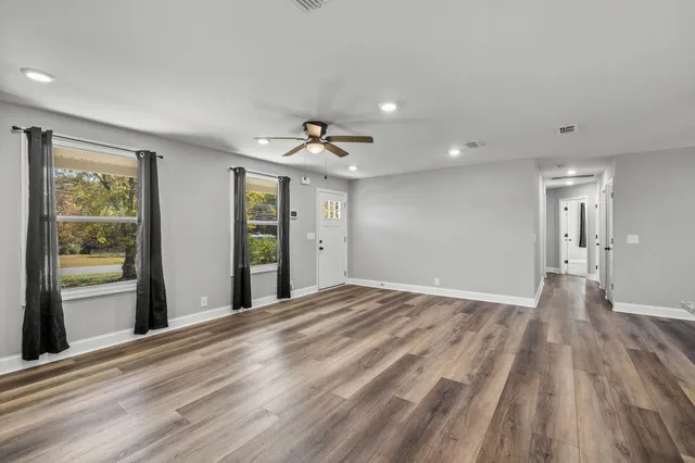 a view of a livingroom with wooden floor and windows