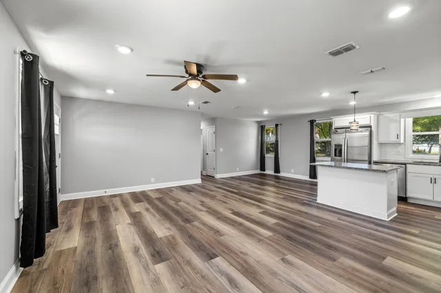 a view of an empty room with kitchen appliances and a window
