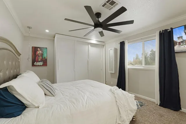 a bedroom with a large bed and a chandelier