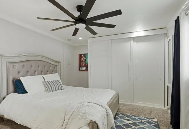 a bedroom with a large bed and a chandelier