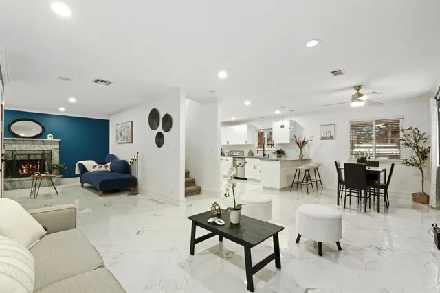 a living room with furniture and a view of kitchen