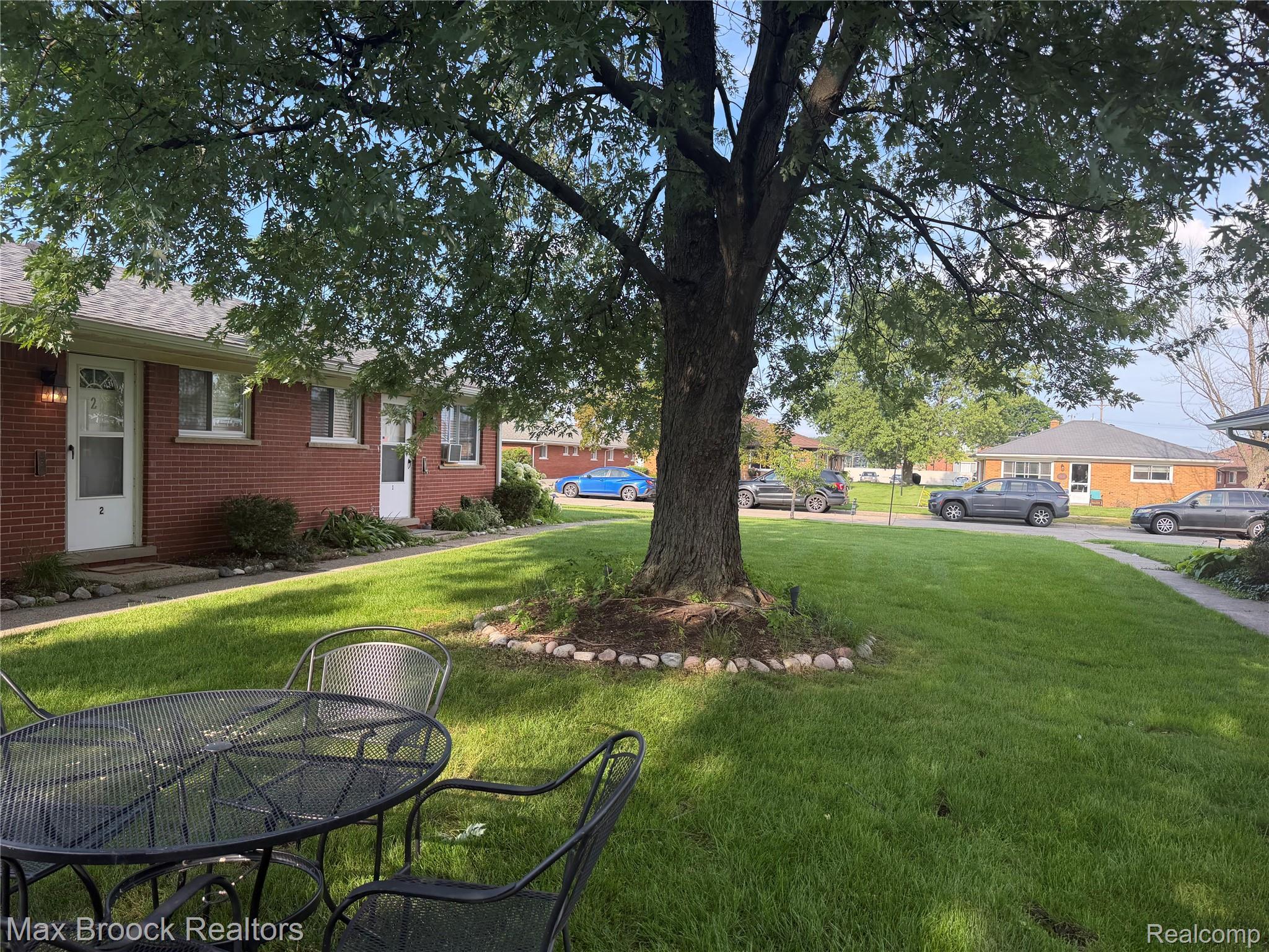 3875 Devon Road, Unit # 9 Royal Oak, MI 48073 - Photo 1 of 17 Manicured lawn with mature shade trees, brick exterior, and white entry doors