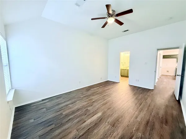 a view of empty room with wooden floor