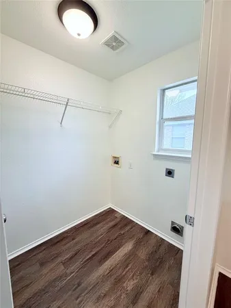 a view of a room with wooden floor and small window