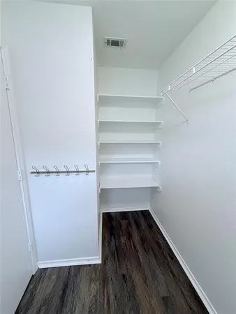 a view of walk in closet with empty racks