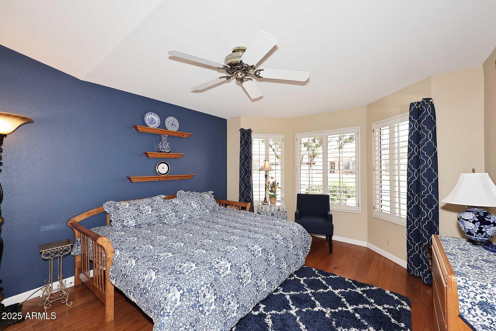9025 West Marco Polo Road Peoria, AZ 85382 - Photo 19 of 38 a bedroom with a bed and wooden floor