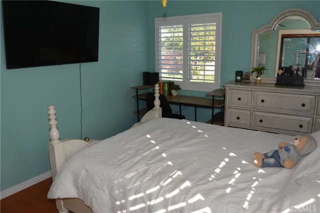 a bedroom with a bed and a mirror on dresser