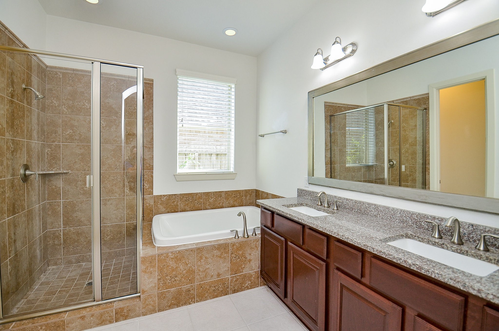 3302 Rochdale Street Houston, TX 77025 - Photo 21 of 49 a bathroom with a granite countertop sink a mirror a bathtub and next to a window