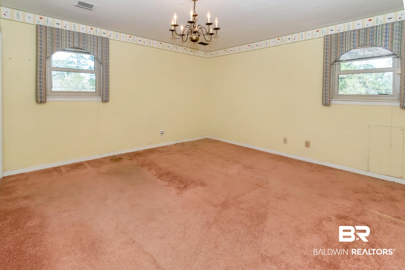 3715 South Conway Drive Mobile, AL 36608 - Photo 12 of 24 Carpeted empty room with baseboards and a notable chandelier