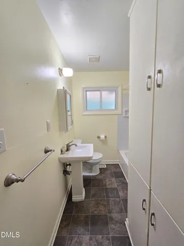 a bathroom with a granite countertop sink a toilet and shower