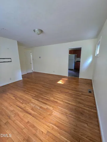 a view of an empty room with wooden floor