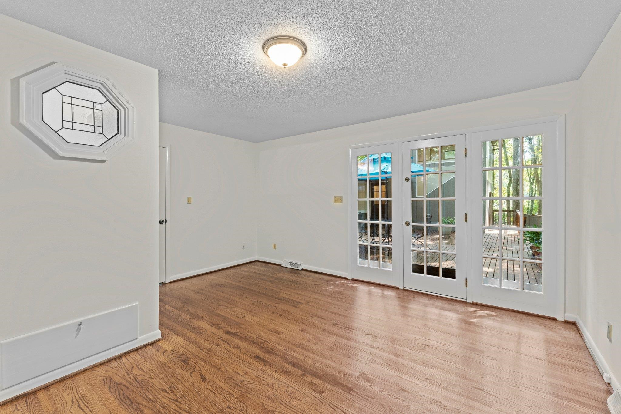 4505 Eliot Place Raleigh, NC 27609 - Photo 22 of 51 Primary Bedroom with private access to back deck. Ornate window into Primary Bathroom. Primary Bedroom