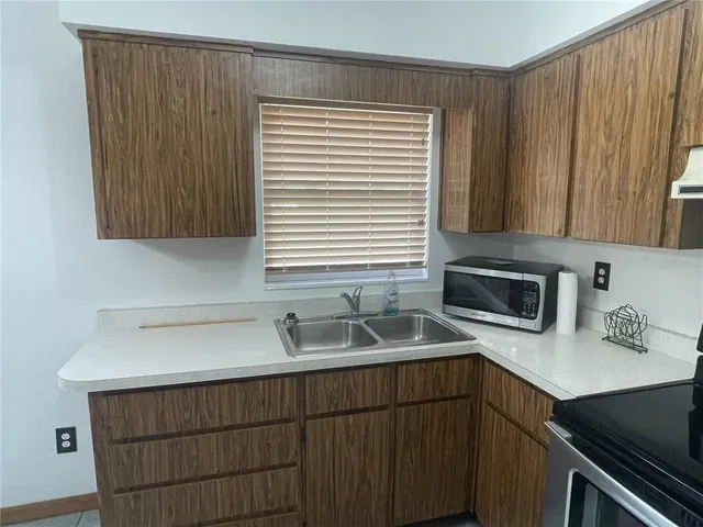 a kitchen with a sink cabinets and a window