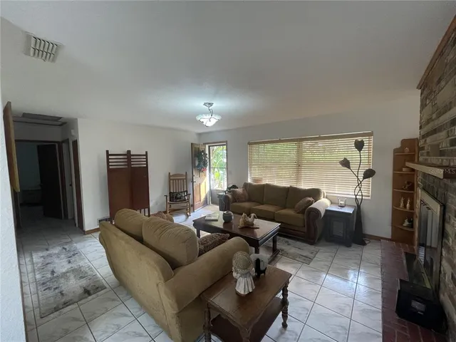 a living room with furniture and a open kitchen view