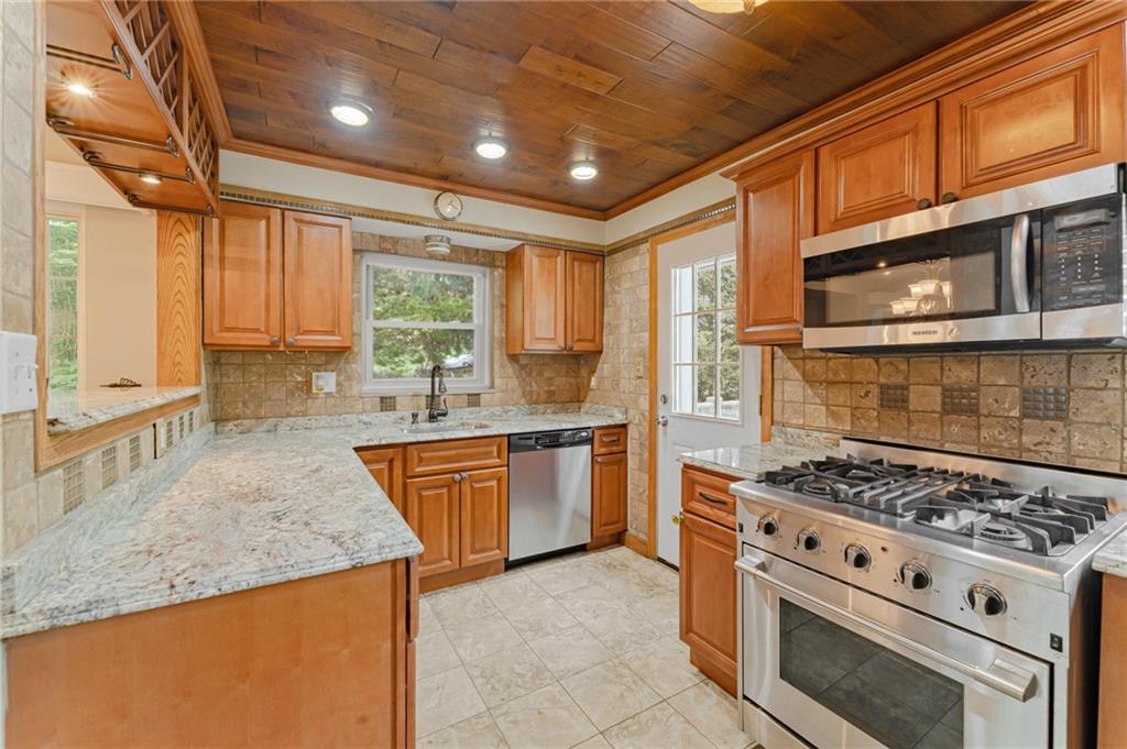 116 Elmore Road Pittsburgh, PA 15221 - Photo 7 of 16 a kitchen with stainless steel appliances granite countertop a stove a sink and a microwave