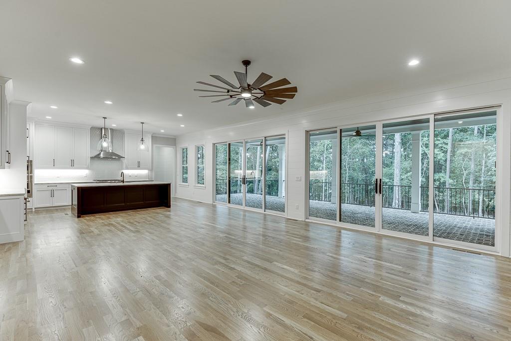7620 Breeze Bay Road Cumming, GA 30041 - Photo 13 of 53 a view of an empty room with a kitchen and wooden floor