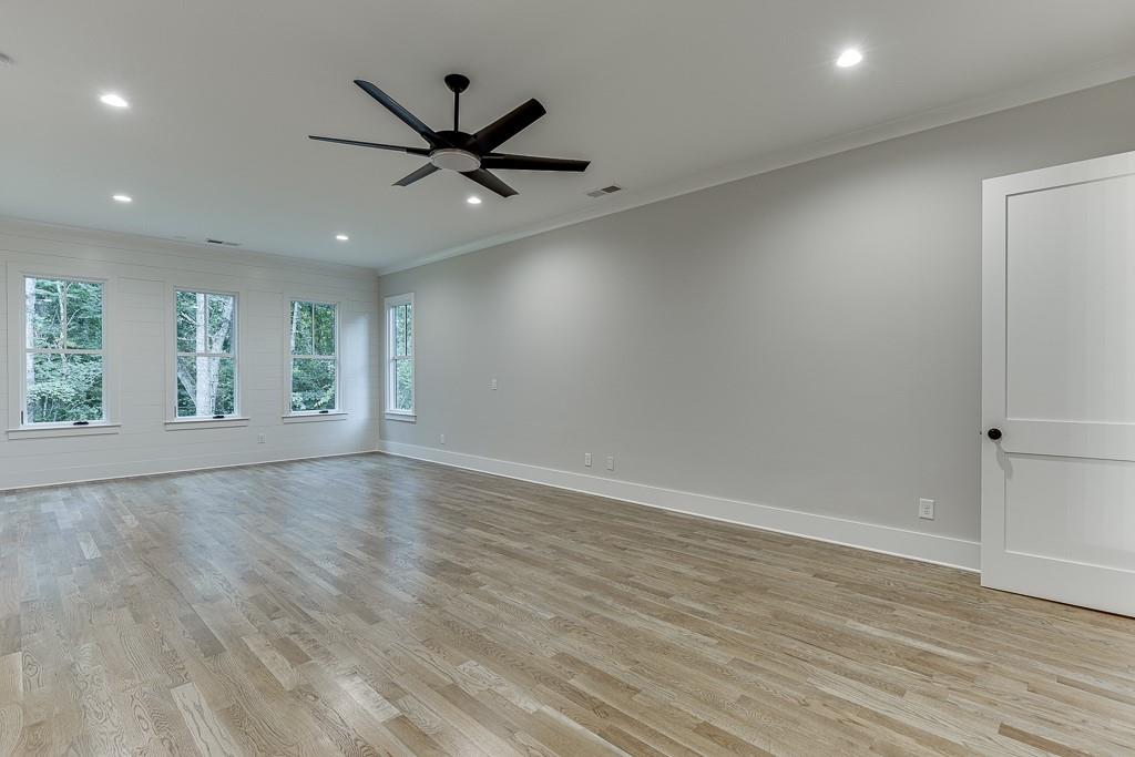 7620 Breeze Bay Road Cumming, GA 30041 - Photo 16 of 53 an empty room with wooden floor fan and windows