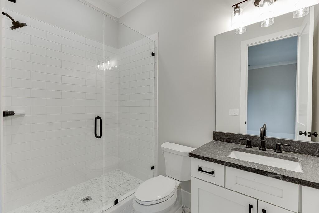 7620 Breeze Bay Road Cumming, GA 30041 - Photo 23 of 53 a bathroom with a sink toilet vanity and shower