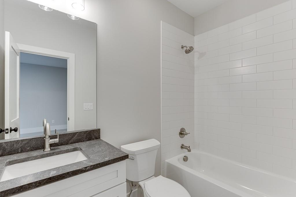 7620 Breeze Bay Road Cumming, GA 30041 - Photo 29 of 53 a bathroom with a granite countertop sink toilet a mirror and shower