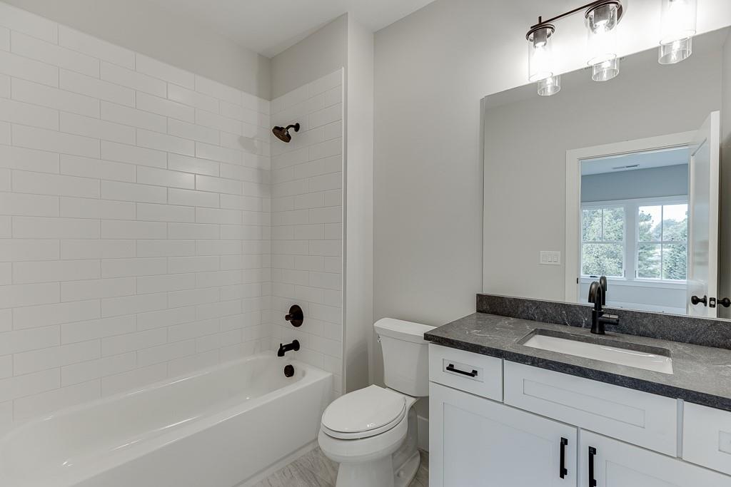 7620 Breeze Bay Road Cumming, GA 30041 - Photo 34 of 53 a bath room with a toilet a sink and a bath tub
