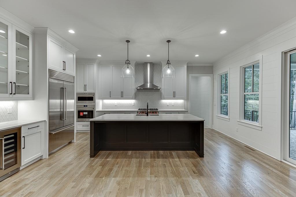 7620 Breeze Bay Road Cumming, GA 30041 - Photo 7 of 53 a view of a kitchen with stainless steel appliances granite countertop a stove and a wooden floors