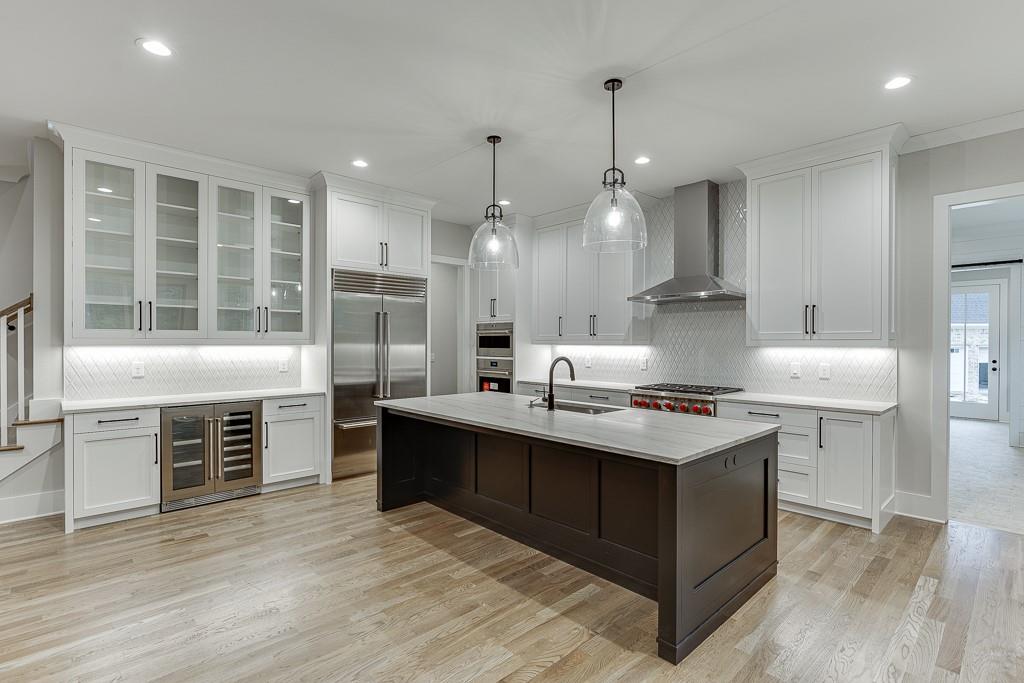 7620 Breeze Bay Road Cumming, GA 30041 - Photo 9 of 53 a kitchen with kitchen island a sink stainless steel appliances and wooden floor