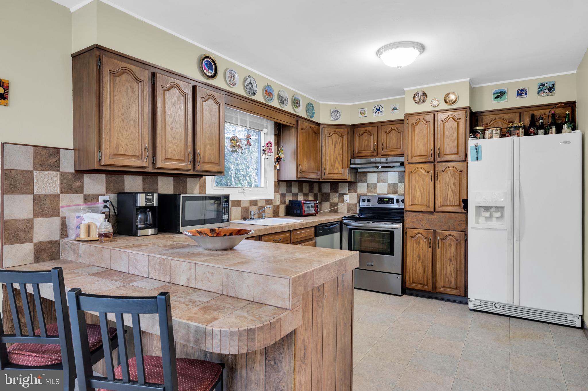 411 North Tulpehocken Road Reading, PA 19601 - Photo 11 of 27 a kitchen with refrigerator a stove a sink and cabinets