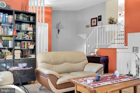 a living room with furniture and a book shelf