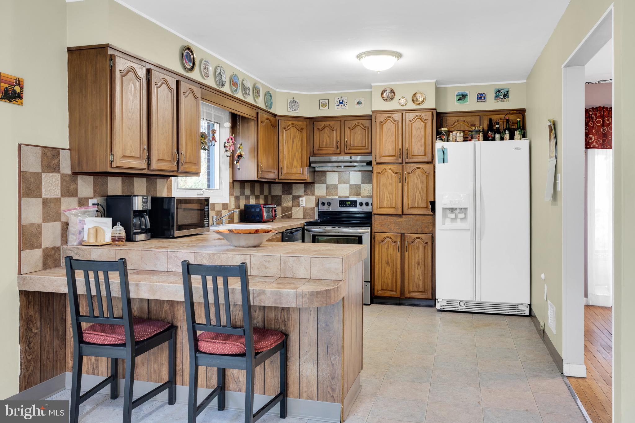 411 North Tulpehocken Road Reading, PA 19601 - Photo 10 of 27 a kitchen with stainless steel appliances granite countertop a refrigerator a stove a sink and white cabinets with wooden floor