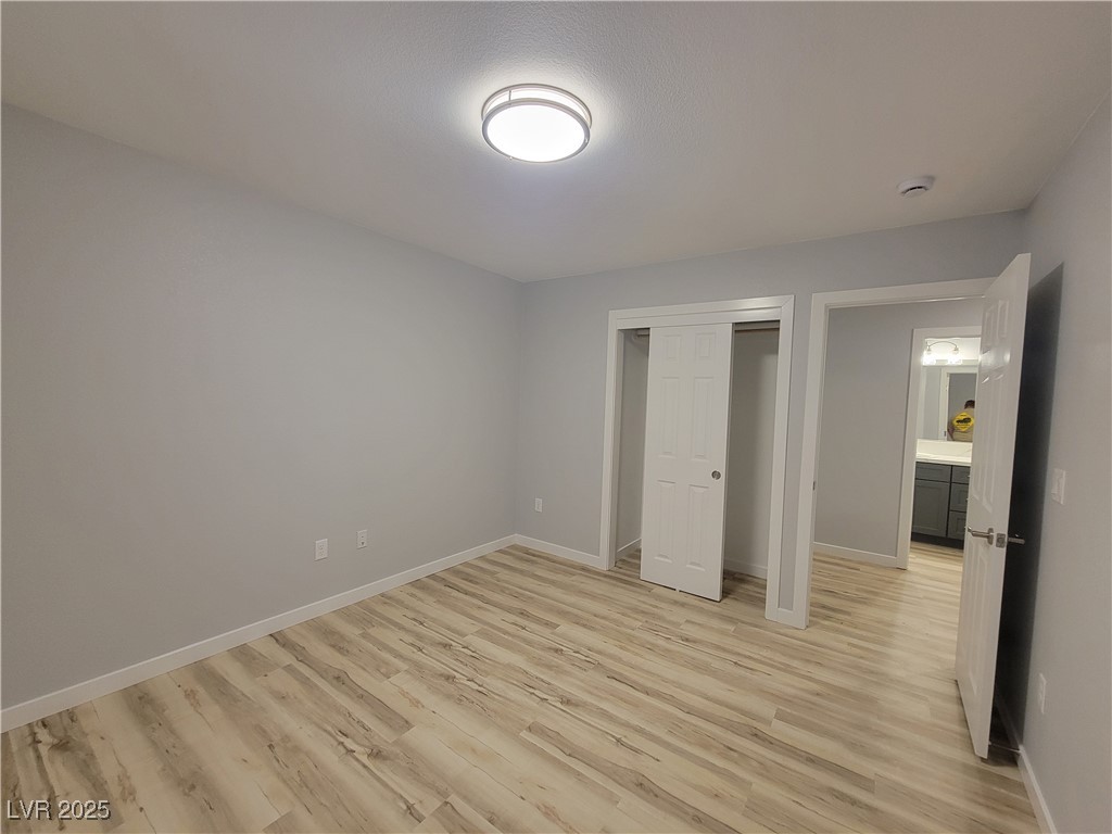 1021 East Manse Road Pahrump, NV 89048 - Photo 10 of 25 Unfurnished bedroom featuring light wood-style floors and a closet