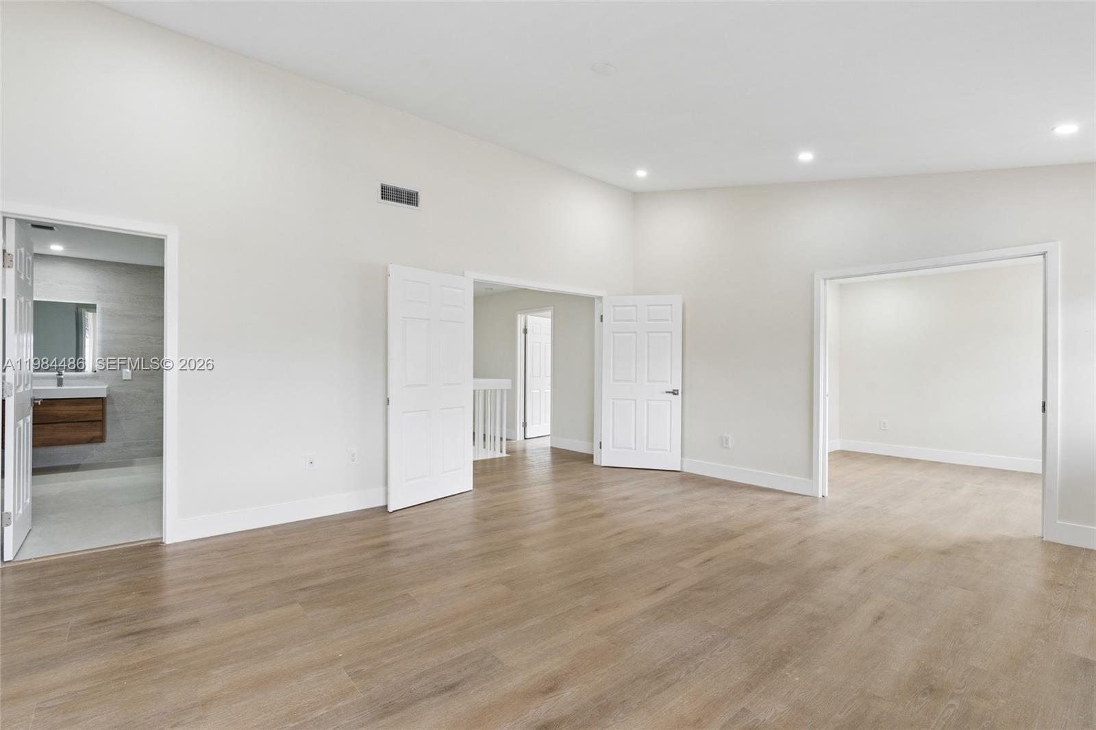 15174 Southwest 111th Street Miami, FL 33196 - Photo 20 of 49 a view of an empty room with wooden floor and a kitchen