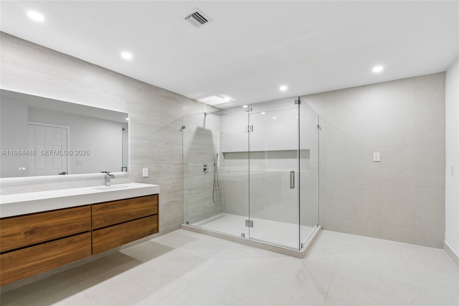 15174 Southwest 111th Street Miami, FL 33196 - Photo 23 of 49 a bathroom with a mirror a shower and a sink