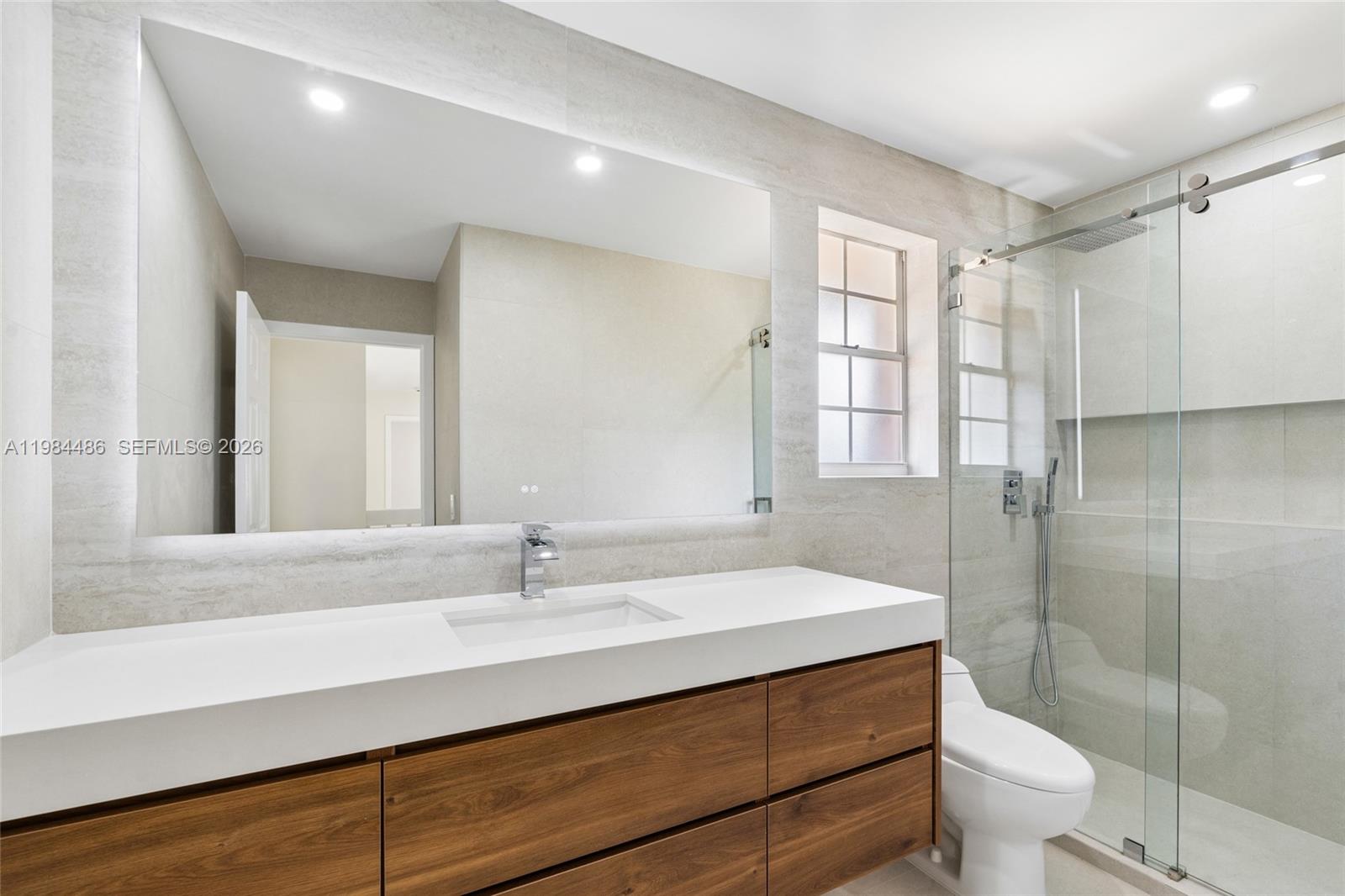 15174 Southwest 111th Street Miami, FL 33196 - Photo 32 of 49 a bathroom with a sink a toilet a mirror and shower