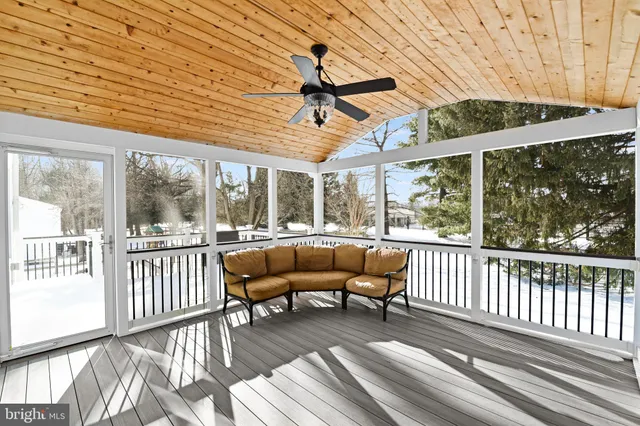 a view of a patio with couches chairs and wooden floor