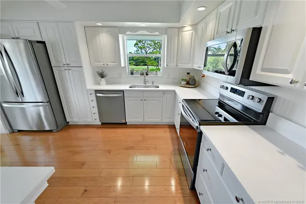 a kitchen with a sink appliances and cabinets