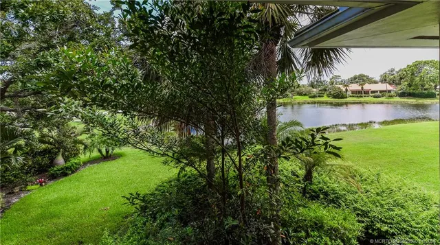 a view of patio with table and chairs under an umbrella