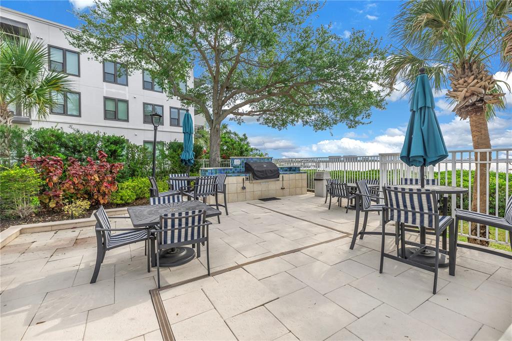4206 Bay Club Circle, Unit 4206 Tampa, FL 33607 - Photo 49 of 60 a view of a patio with a table and chairs and potted plants