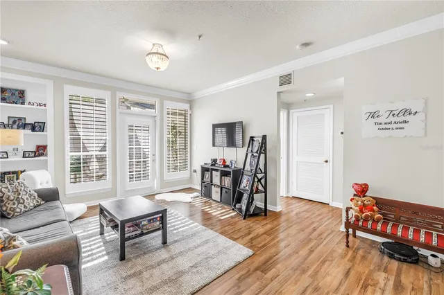 a living room with furniture and a dining table with wooden floor