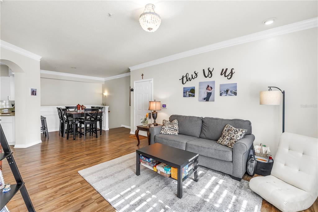 4206 Bay Club Circle, Unit 4206 Tampa, FL 33607 - Photo 6 of 60 a living room with furniture and a dining table with wooden floor