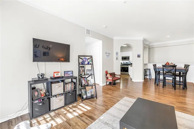 a kitchen with stainless steel appliances a dining table chairs and a refrigerator
