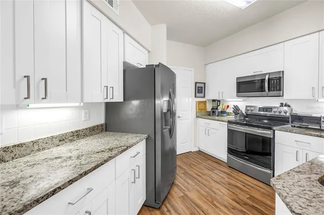 a kitchen with stainless steel appliances a stove a microwave and cabinets