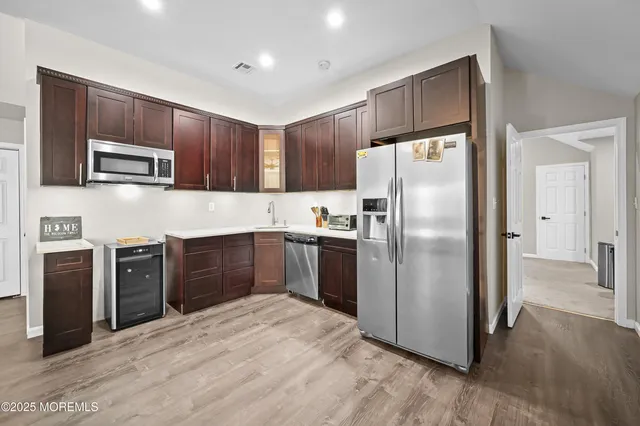 a kitchen with granite countertop stainless steel appliances a refrigerator cabinets and microwave